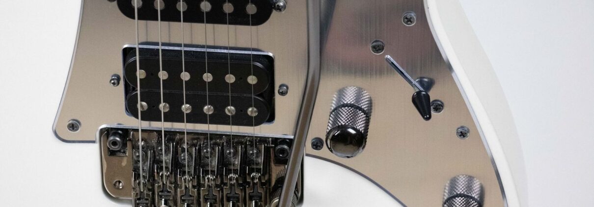 Nahaufnahme einer E-Gitarre mit Tremolohebel und mehreren Tonabnehmern