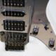 Nahaufnahme einer E-Gitarre mit Tremolohebel und mehreren Tonabnehmern