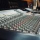Nahaufnahme eines analogen Mischpults im Tonstudio mit vielen Reglern
